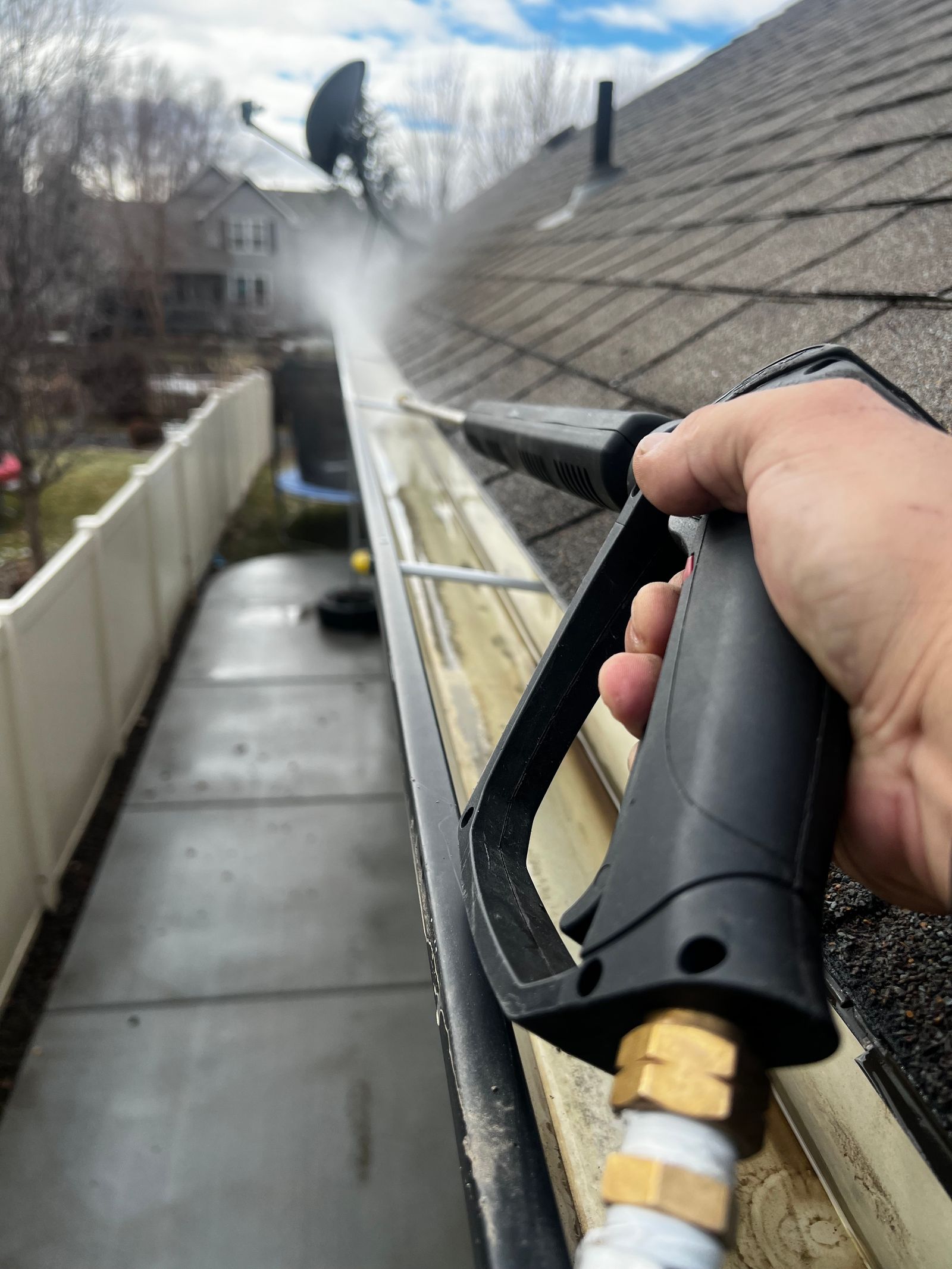 Clean gutter being flushed by professional cleaner